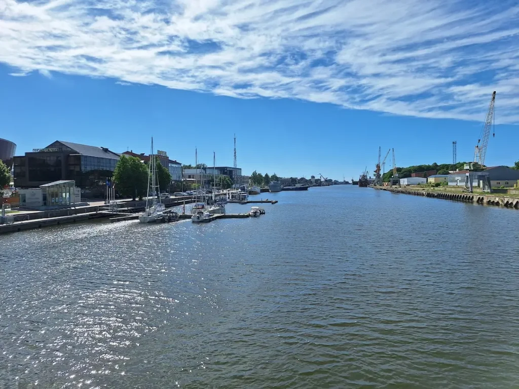 View along the Trade Canal in Liepāja with boats, cranes, and waterfront buildings showing many things to do in liepaja