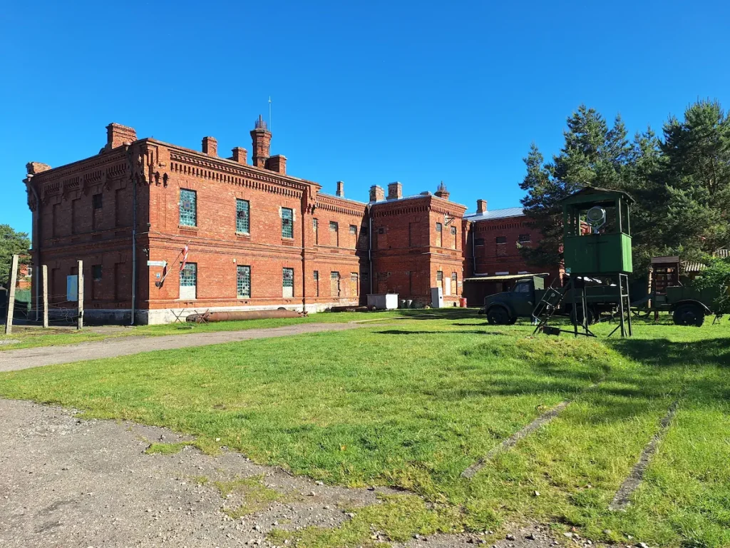exterios of karosta prison cietums in Liepāja showing old military trucks and a guard post