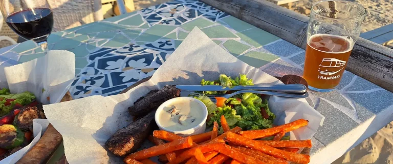 best restaurants in liepaja showing sweet fries beer and wine in a beach setting
